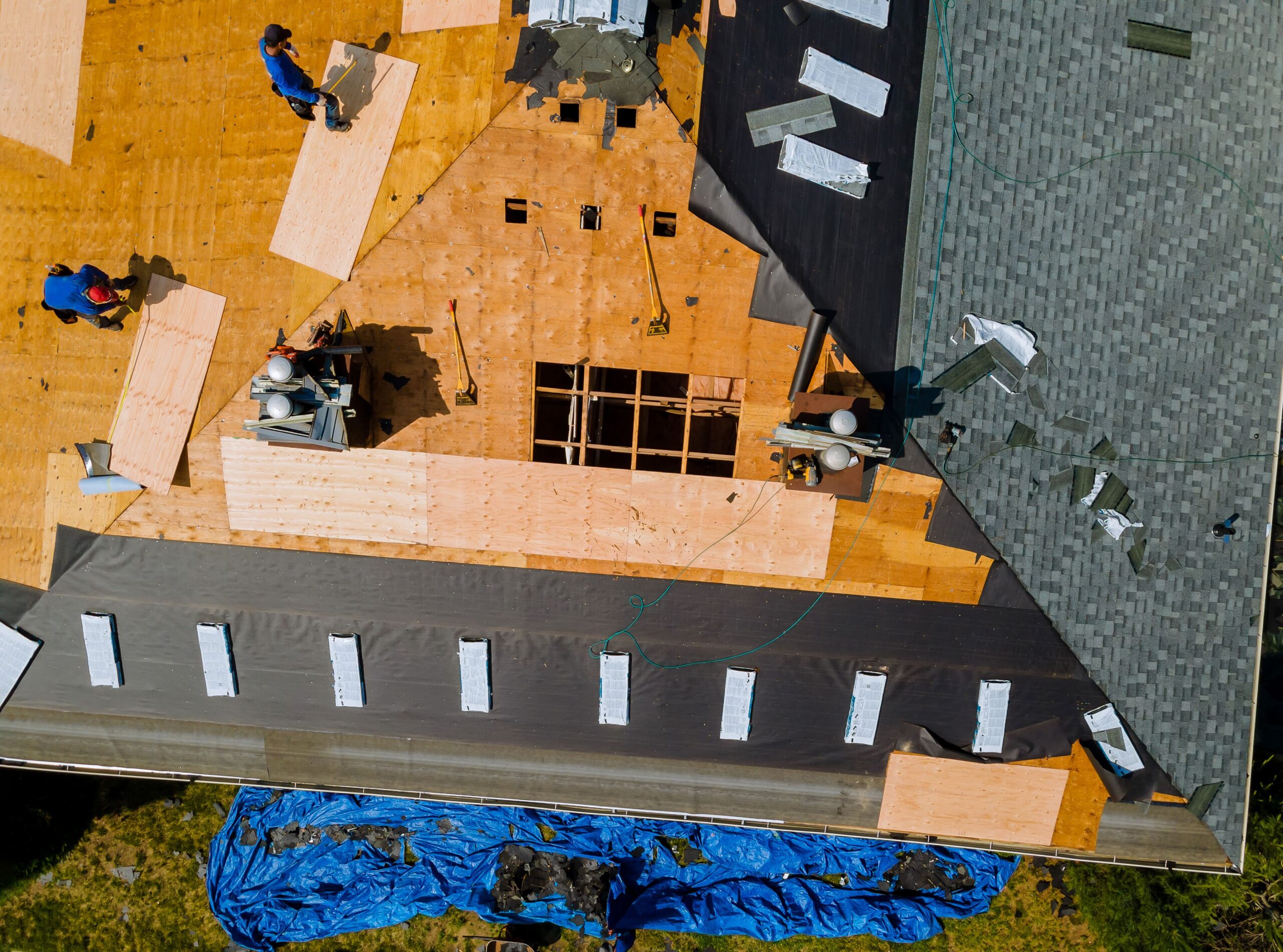 roofers removing a section of shingles from residential roof